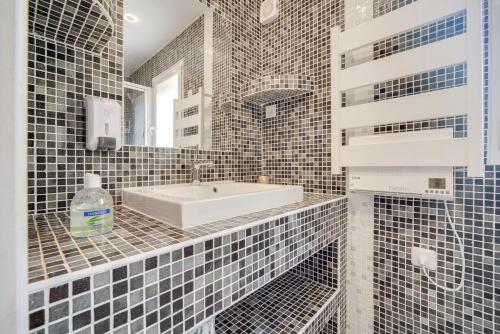 une salle de bain avec un lavabo et un miroir dans l'établissement La Sérénade Numéro 1, à Montreuil