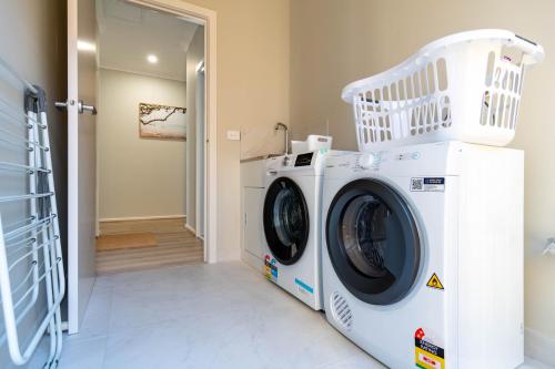 a washer and dryer in a laundry room at Modern 5bedrooms Clyde home in Clyde