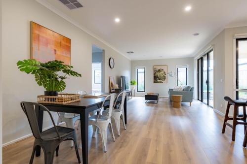 a dining room and living room with a table and chairs at Modern 5bedrooms Clyde home in Clyde