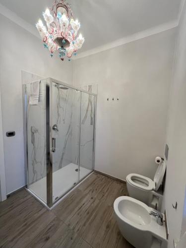 a bathroom with a shower and a toilet and a chandelier at La CONCHIGLIA Bed & Breakfast in Camogli