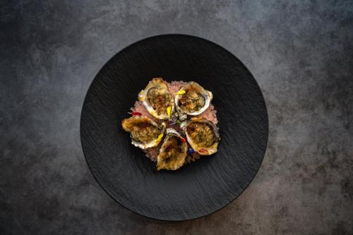 a black plate of food on a table at Hotel Indigo La Paz Puerta Cortes by IHG in La Paz