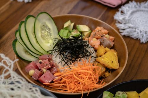 a bowl of food with cucumbers and meat and vegetables at Hotel Indigo La Paz Puerta Cortes by IHG in La Paz