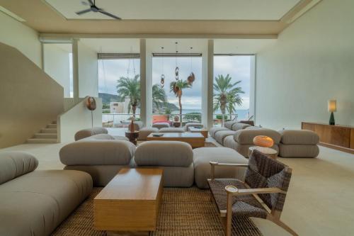 a living room with couches and tables and windows at Hotel Indigo La Paz Puerta Cortes by IHG in La Paz