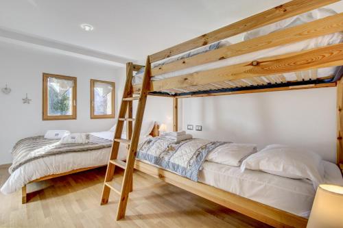 une chambre avec deux lits superposés et une échelle dans l'établissement Les Berberis - Snow and Trek, à Morzine