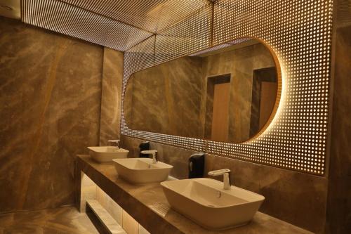 a bathroom with two sinks and a large mirror at Regenta - The World Surat in Surat