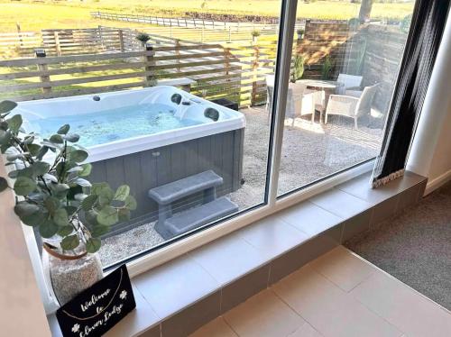 a hot tub in a window with a potted plant at Clover Lodge in Chesterfield