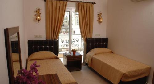 une chambre d'hôtel avec deux lits et une fenêtre dans l'établissement GTH GLORİA GÜMBET HOTEL, à Bodrum City