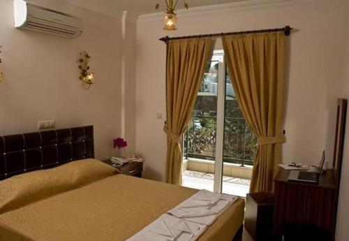 a bedroom with a bed and a large window at GTH GLORİA GÜMBET HOTEL in Bodrum City