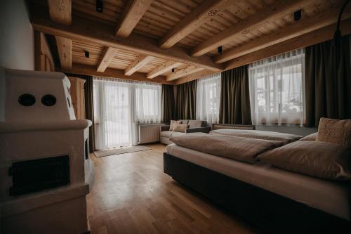 ein großes Wohnzimmer mit einem Bett und einem Kamin in der Unterkunft FRÄULEIN NANNERL - Boutique Aparthotel in Gerlos