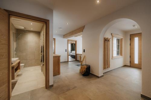 a bathroom with a walk in shower and a sink at FRÄULEIN NANNERL - Boutique Apart mit Saunahaus in Gerlos