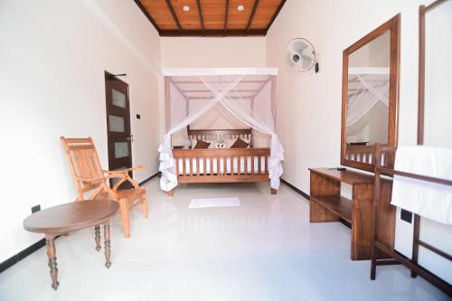 a bedroom with a crib and a table and chair at Dream Villa - Tangalle in Tangalle