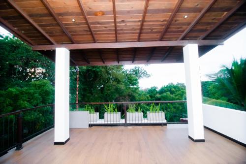 a porch with a wooden ceiling and white chairs at Dream Villa - Tangalle in Tangalle