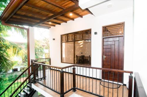 a house with a balcony with a wooden door at Dream Villa - Tangalle in Tangalle