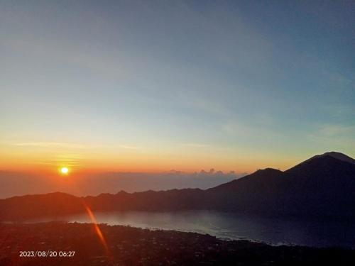 a view of the sun setting over the water at jeep sunrise and trakking in Kintamani