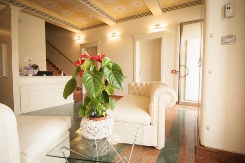 a living room with a white couch and a plant at Hotel Villa Maranello in Maranello