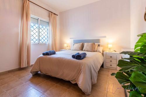 ein Schlafzimmer mit einem Bett mit zwei blauen Handtüchern darauf in der Unterkunft Chalet en la misma playa in Punta Umbría