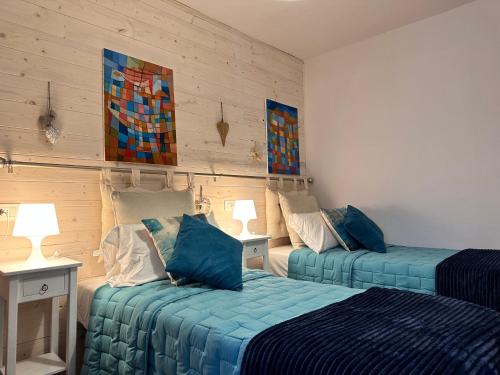 2 camas en una habitación con paredes de madera en Amiter Bagni San Filippo, en Bagni San Filippo