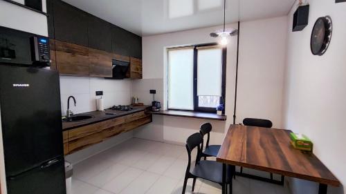 a small kitchen with a wooden table and chairs at Водопійна 25 CityRooms in Bila Tserkva