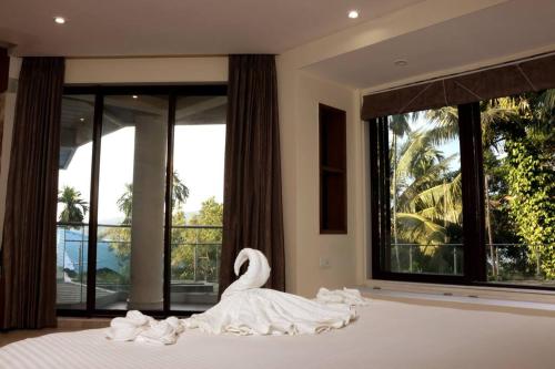 Un cisne está sentado en una cama en un dormitorio en Villa by the Sea en Port Blair