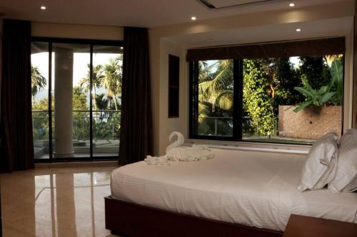 sypialnia z dużym łóżkiem i dużym oknem w obiekcie Villa by the Sea w mieście Port Blair