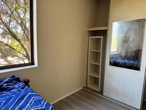 um quarto com uma cama e uma janela em A private room in a homestay!! em Bankstown