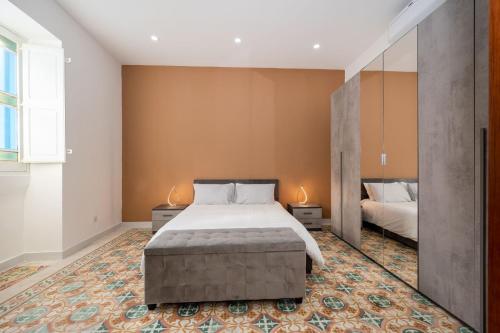 een slaapkamer met een groot bed en 2 lampen bij House of character in Rabat in Busugrilla