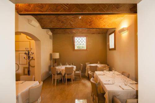jadalnia ze stołami i krzesłami oraz oknem w obiekcie Hotel Villa Maranello w mieście Maranello