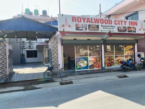 ein Restaurant mit Fahrrädern, die vor einem Gebäude geparkt sind in der Unterkunft Royalwood City Inn in Birātnagar