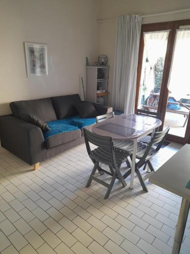 un salon avec une table et un canapé dans l'établissement AGREABLE VILLA DANS LA MARINA AVEC PISCINE, à Saint-Cyprien