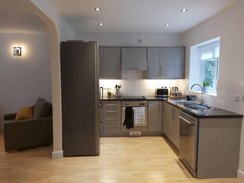 a kitchen with stainless steel appliances and a couch at Peaceful marina-side house in north Wales in Caernarfon