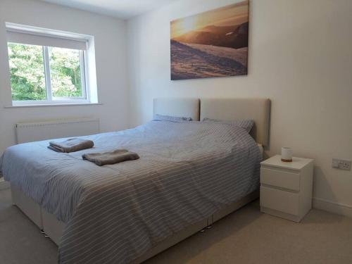 a bedroom with a bed with two towels on it at Peaceful marina-side house in north Wales in Caernarfon