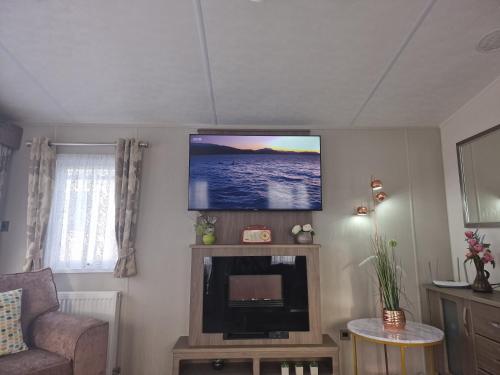 a living room with a flat screen tv on the wall at Seaview in Leysdown-on-Sea