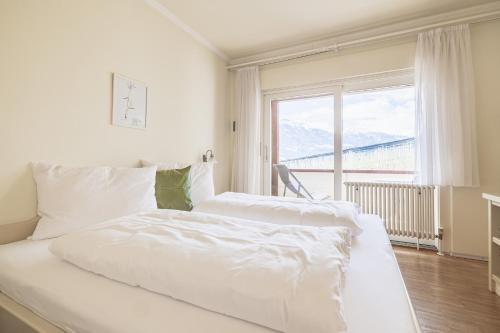 two beds in a bedroom with a large window at Wanda Apartments in Parcines