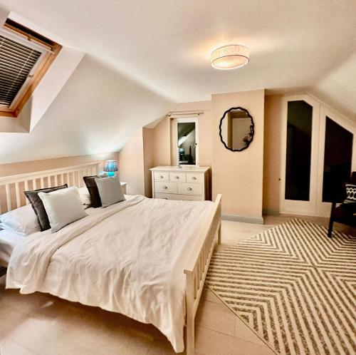 a bedroom with a large white bed and a rug at Spring Cottage, Little Haven, a minute from beach in Little Haven