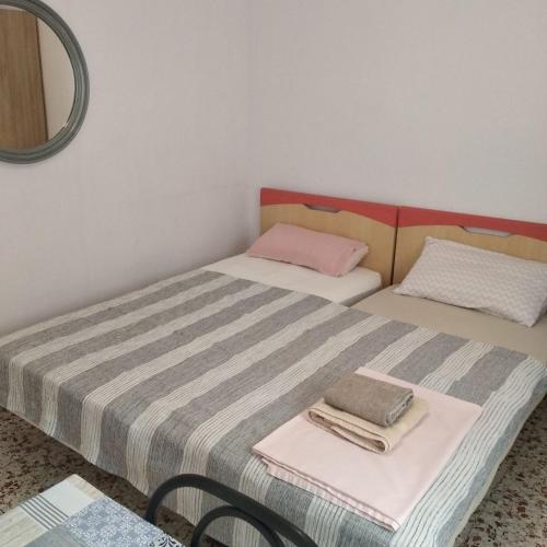 two twin beds in a room with a mirror at Сozy House in Alicante