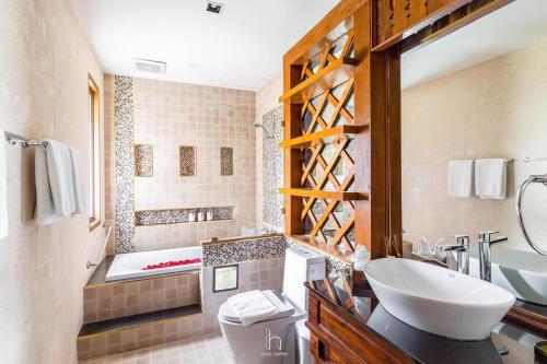 a bathroom with a tub and a sink and a toilet at Phra Singh Village in Chiang Mai