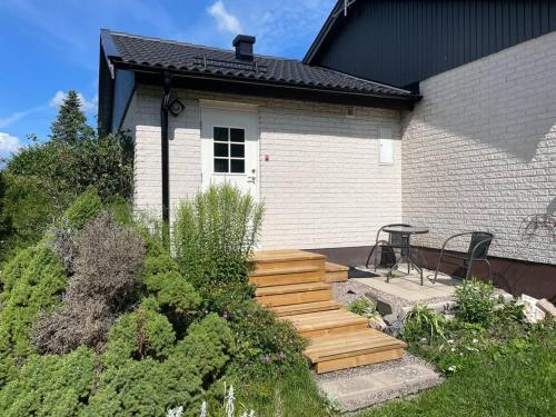 Casa con una escalera de madera que conduce a un patio en Lägenhet med uteplats, en Karlskoga