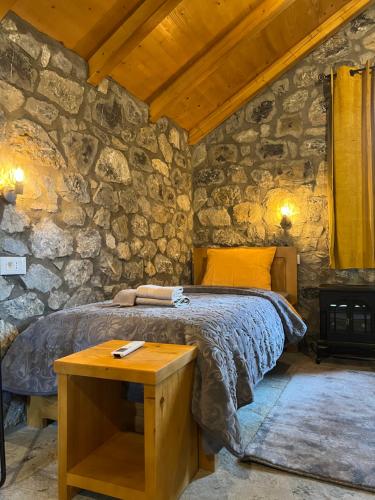 una camera con un letto in una parete in pietra di Cottages Serdar a Mojkovac