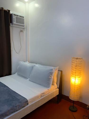 a bedroom with a bed with a heater and a lamp at Dadods homestay in General Luna