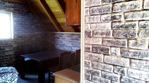 Habitación con mesa y pared de ladrillo en Visočica, 