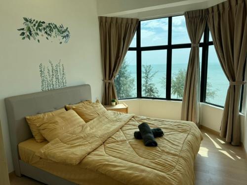 a bed in a bedroom with a large window at Mutiara Melaka Beach Resort by Minso in Tangga Batu