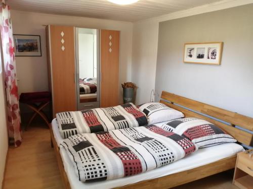 een slaapkamer met 2 bedden en een spiegel bij Das Ferienhäusle in Utarp