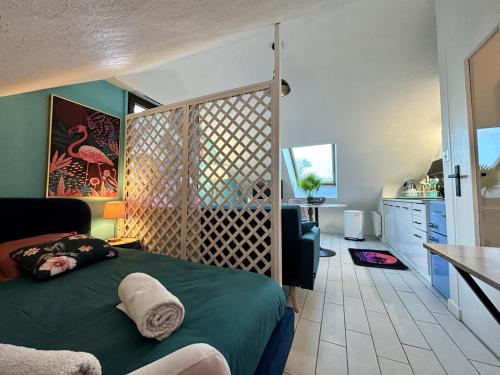 una camera con letto verde e una cucina di -Tropical Studio- Paisible Parking Wifi Lave-Linge a Quimper