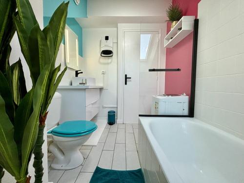 e bagno con vasca, servizi igienici e pianta. di -Tropical Studio- Paisible Parking Wifi Lave-Linge a Quimper