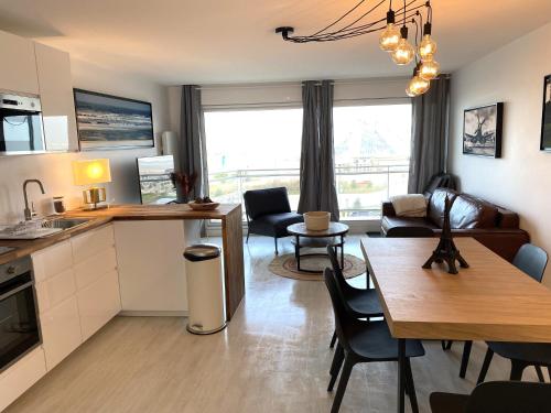 une cuisine et un salon avec une table et des chaises dans l'établissement T2 cabine traversant vue front de mer Le Touquet Paris-Plage, à Le Touquet-Paris-Plage