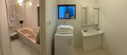 a bathroom with a sink and a toilet and a bath tub at 孔雀民宿 in Osaka