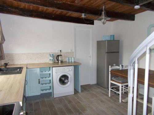 een keuken met een wasmachine en een wasmachine bij La Petite Maison, idéal pour velo,pied,peche,relax in Mur-de-Bretagne
