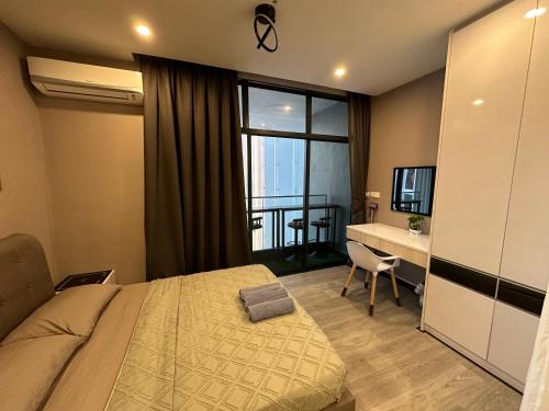 a bedroom with a bed and a desk and a window at Seaview Designer Concept The shore Kota Kinabalu Sabah by UsHomestay in Kota Kinabalu