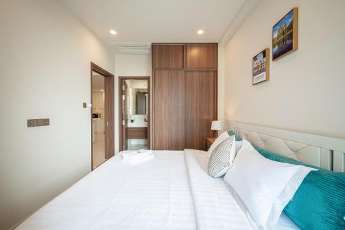 a bedroom with a large white bed in a room at Metropole Thu Thiem Condo Apartment in Ho Chi Minh City