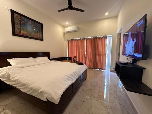 a bedroom with a bed and a flat screen tv at Hidden beach stay in Chennai
